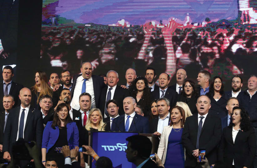 Prime Minister Benjamin Netanyahu and his wife, Sara, are joined by Likud members in the singing of ‘Hatikvah’ after celebrating their victory on April 10 (photo credit: MARC ISRAEL SELLEM)