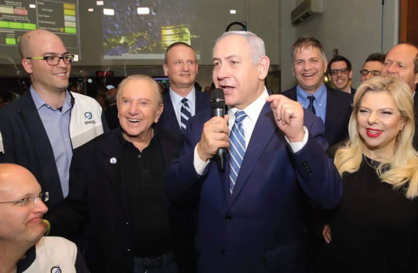 Prime Minister Benjamin Netanyahu (center) is flanked by (from left) two of the SpaceIL co-founders Yariv Bash, Yonatan Winetraub, SpaceIL President Morris Kahn and IAI Chairman Harel Locker, and his wife Sara (from the right) (photo credit: SPACEIL IAI)