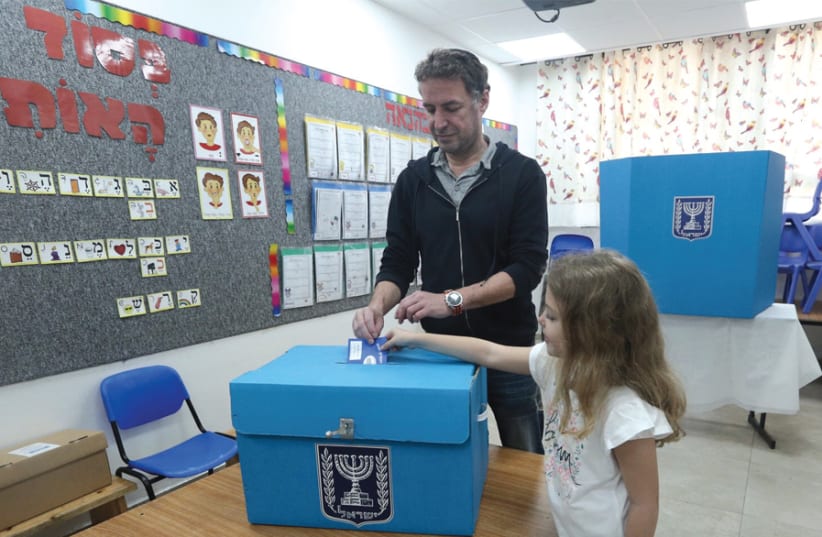 A man votes with his daughter at a polling station in Jerusalem on April 9 (photo credit: MARC ISRAEL SELLEM)