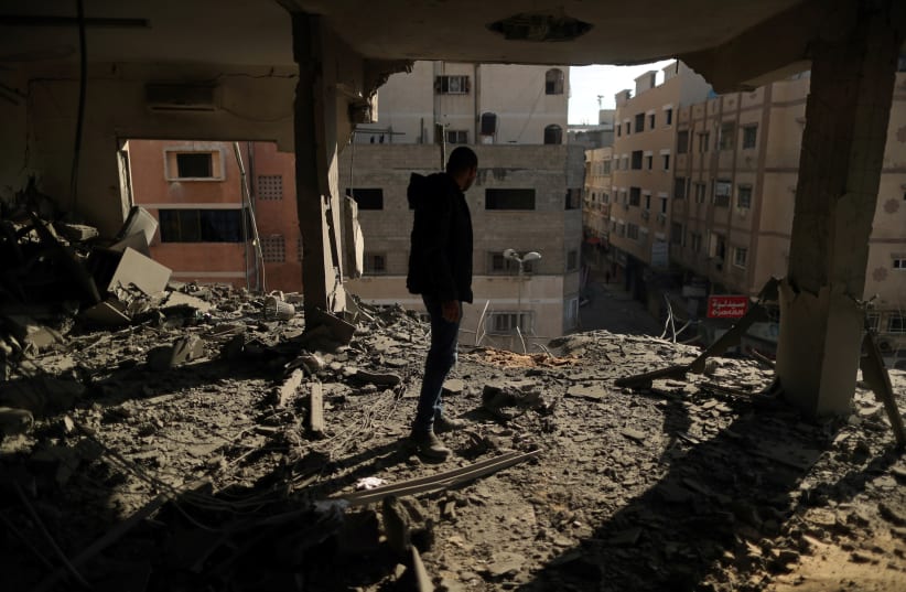 A Palestinian man inspects a building destroyed in Israeli air strikes, in Gaza City May 5, 2019 (photo credit: SUHAIB SALEM / REUTERS)