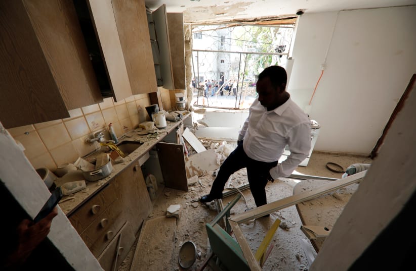 Israeli member of parliament, Gadi Yevarkan, looks at debris in a flat located in an apartment block that was damaged after it was hit by a rocket fired from Gaza (photo credit: AMIR COHEN/REUTERS)