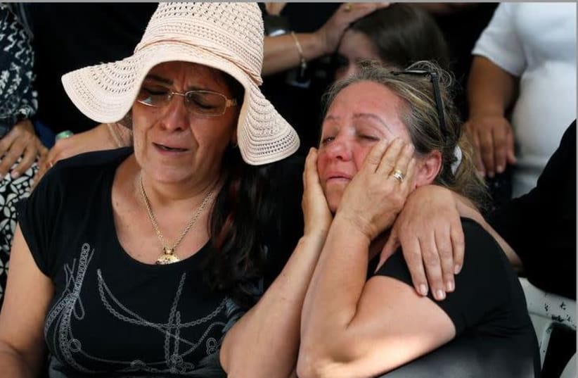 Friends and relatives mourn during the funeral of Moshe Agadi, an Israeli man who was killed after a rocket fired from Gaza hit his house, during cross-border hostilities, in the southern Israeli city of Ashkelon May 5, 2019.  (photo credit: REUTERS/Ronen Zvulun)