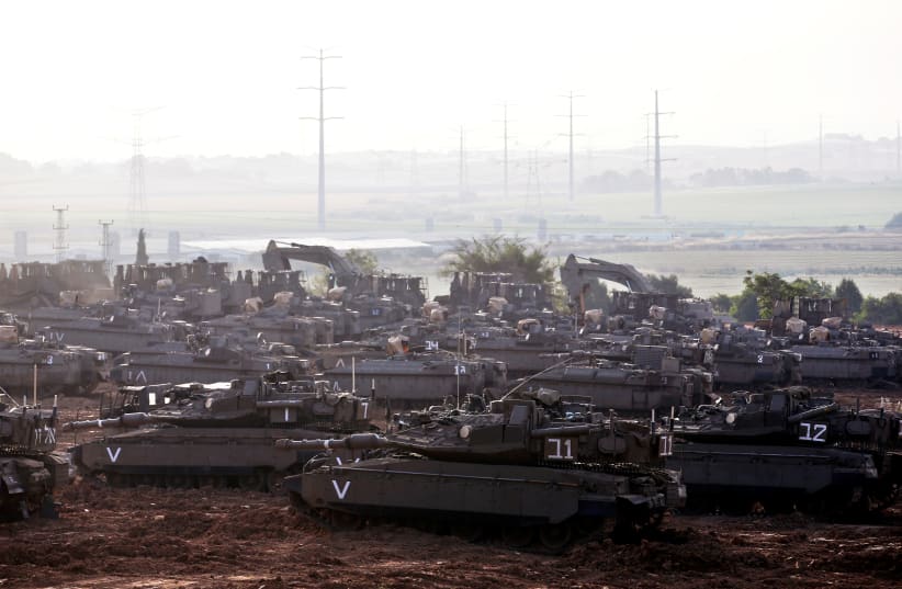 Israeli tanks, armoured personnel carriers (APC) and other military armoured vehicles gather near the border with Gaza, in southern Israel (photo credit: RONEN ZVULUN/REUTERS)