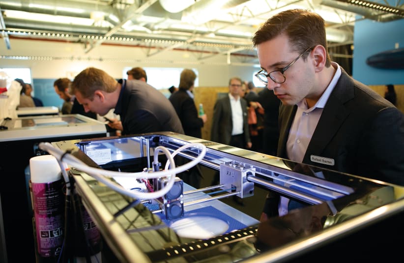 A MAN watches a 3D Printer in action while attending a conference.  (photo credit: TRINITY WHEELER PHOTOGRAPHY)