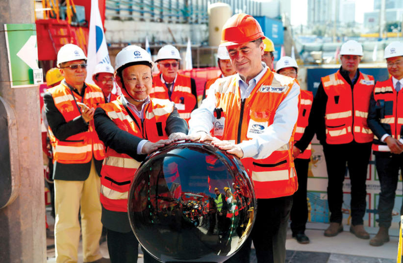 TRANSPORTATION MINISTER Israel Katz (front) and employees of China Railway Engineering Corporation take part in an event marking the beginning of underground construction work of the light rail, using a tunnel boring machine, in Tel Aviv in February 2017. (photo credit: REUTERS)