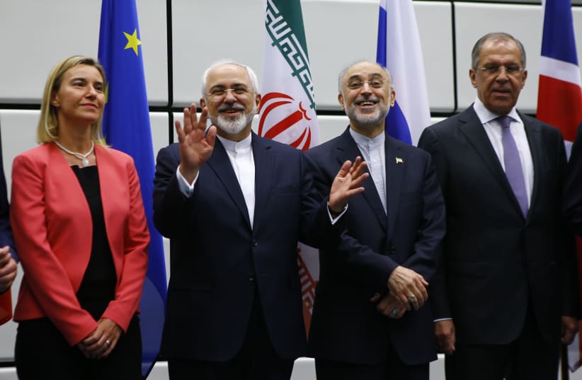 Iran FM Zarif, EU Rep. for Foreign Affairs Mogherini, and Iranian and Russian officials at signing of nuclear deal in Vienna, 2015 (photo credit: LEONHARD FOEGER / REUTERS)
