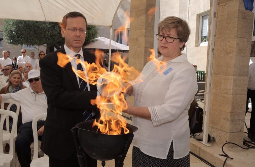  Marnie Fienberg, the daughter-in-law of Joyce Fienberg, who was murdered in the Pittsburgh synagogue attack, lights a memorial torch together with Chairman of The Jewish Agency for Israel Isaac Herzog (photo credit: NOAM SHARON)