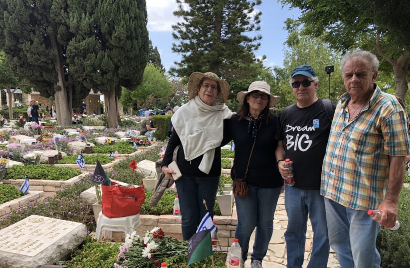 Etti Mansour (L) and Chaim Nechustan (R) next to the grave of Shlomo Laniado who fell in the Yom Kippur War (photo credit: Courtesy)