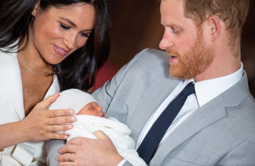 Britain's Prince Harry and Meghan, Duchess of Sussex hold their baby son, who was born on Monday morning, during a photocall in St George's Hall at Windsor Castle, in Berkshire, Britain May 8, 2019 (photo credit: DOMINIC EBENBICHLER/REUTERS)