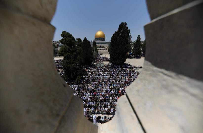 The Dome of the Rock is seen in the background as Palestinians pray on the first Friday of Ramadan in 2018 (photo credit: AMMAR AWAD/REUTERS)