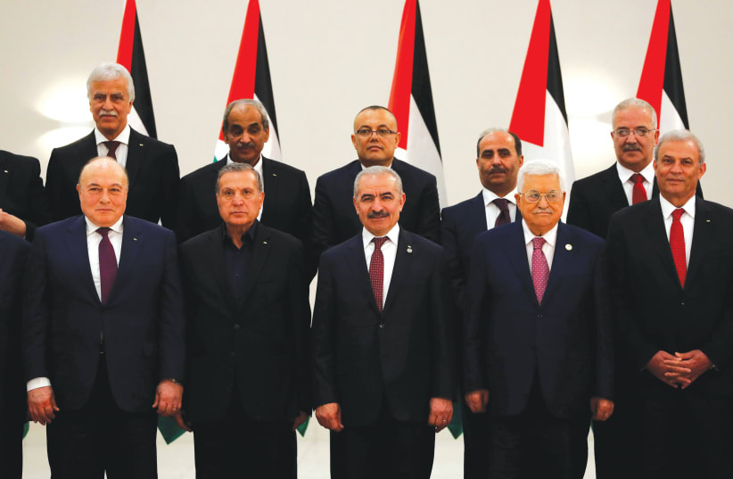 PALESTINIAN AUTHORITY PRESIDENT Mahmoud Abbas, Prime Minister Mohammad Shtayyeh (third left) and other members of the new government attend the swearing-in ceremony in Ramallah last month. (photo credit: MOHAMAD TOROKMAN/REUTERS)