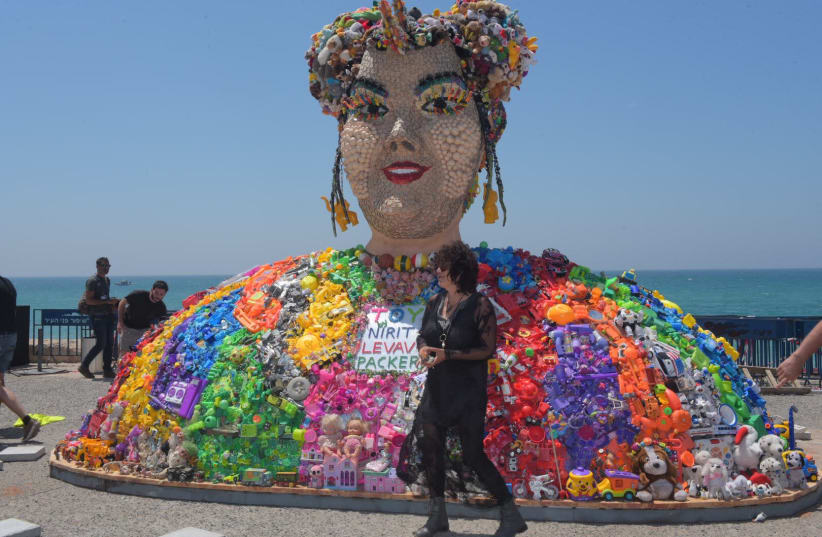 Artist Nirit Levav Packer stands in front of her sculpture of Neta Barzilai made from dolls, Tel Aviv 2019 (photo credit: AVSHALOM SASSONI)