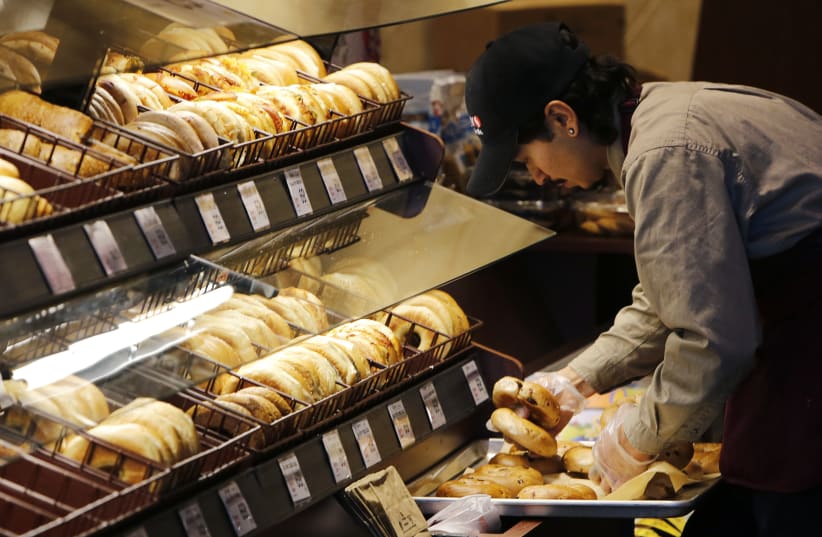 A baker puts out fresh bagels at the store, 2015. (photo credit: REUTERS/GARY CAMERON)