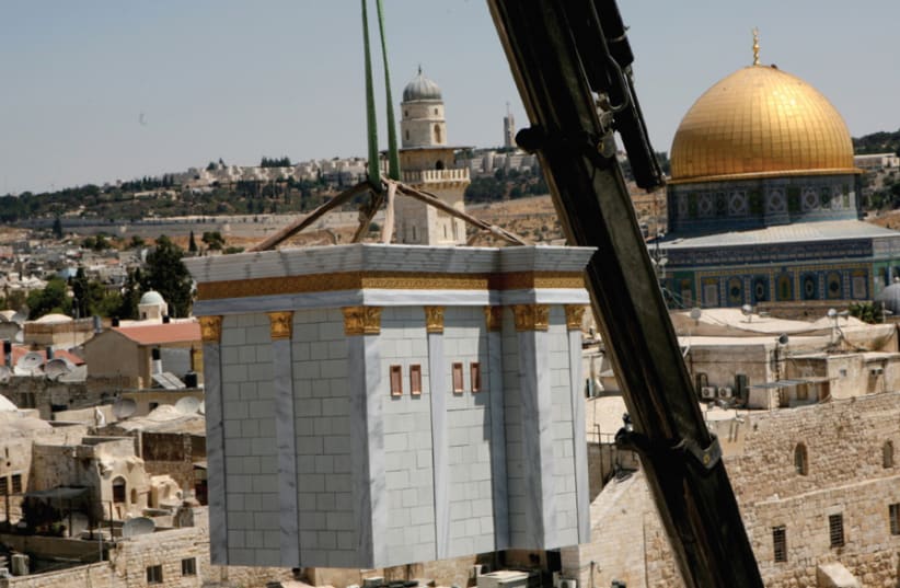 A model of the Temple is lowered by crane onto the roof of the Aish HaTorah Yeshiva in the Jewish Quarter in 2009 (photo credit: GALI TIBBON)