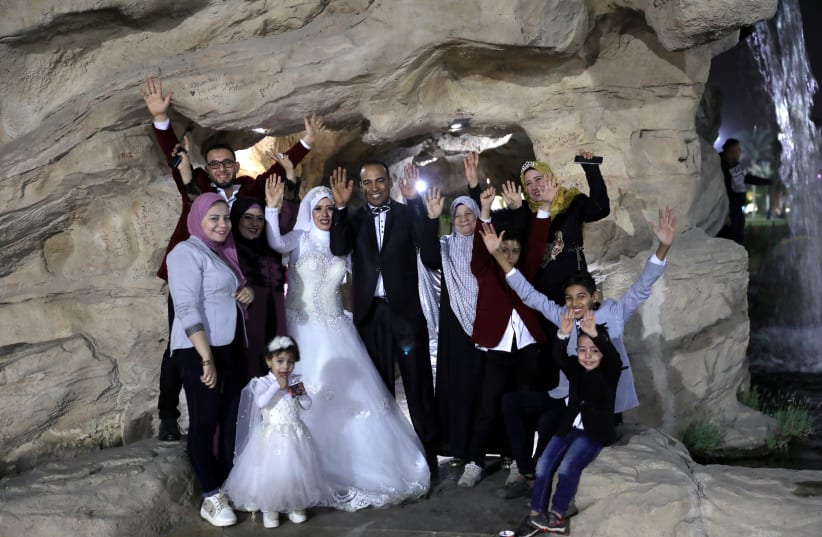Nadia Mohammad Salem and her husband celebrate with family on their wedding day, in Cairo, Egypt  (photo credit: HAYAM ADEL/REUTERS)