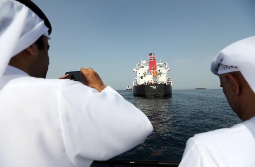 Port officials take a photo of a damaged Andrea Victory ship at the Port of Fujairah, United Arab Emirates, May 13, 2019 (photo credit: SATISH KUMAR/REUTERS)