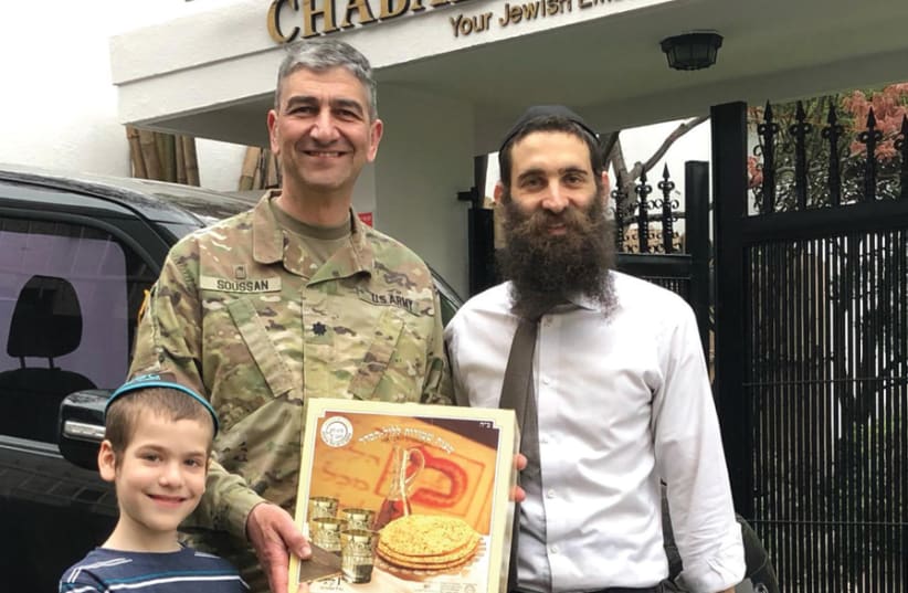 AT CHABAD Korea, Rabbi Osher Litzman gifts a box of shmurah matzah to US Chaplain Rabbi Henry Soussan. (photo credit: Courtesy)