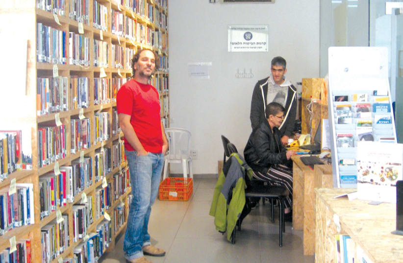 IRAD EICHLER (left) in Rebooks, Kfar Saba, with two store workers (photo credit: CARL HOFFMAN)
