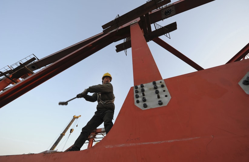 A labourer works at a high-speed railway viaduct construction site in Hefei, Anhui province January 4, 2011. (photo credit: REUTERS)
