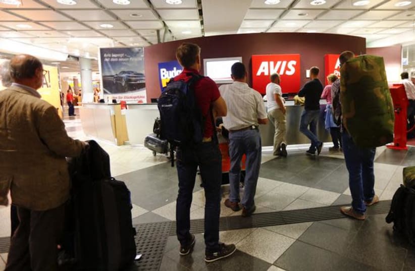 People queue at rental car desks at the international airport in Munich (photo credit: REUTERS/MICHAEL DALDER)