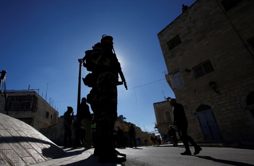A member of Palestinian security forces stands guard in Bethlehem, in the West Bank (photo credit: MUSSA QAWASMA / REUTERS)