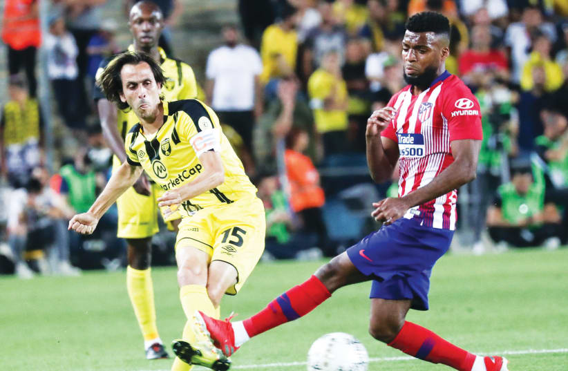 BEITAR JERUSALEM midfielder Yossi Benayoun (left) shoots past Atletico Madrid’ Thomas Lemar during last night’s friendly between the clubs at Teddy Stadium in Jerusalem, where Beitar notched a surprising 2-1 victory. (photo credit: DANNY MARON)