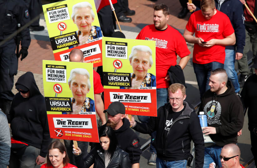 Far-right supporters of the party "Die Rechte (The Rights) carry placards of 90-year-old Ursula Haverbeck, who is imprisoned for her denial of the Holocaust during their May Day rally through the streets of Duisburg, Germany, May 1, 2019 (photo credit: WOLFGANG RATTAY / REUTERS)