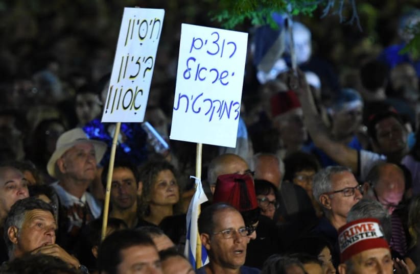 Left wing Israelis hold sign stated "we want a democratic Israel" at a rally against Prime Minister Benjamin Netanyahu and in support of the Supreme Court in Tel Aviv, May 25, 2019 (photo credit: AVSHALOM SASSONI/ MAARIV)
