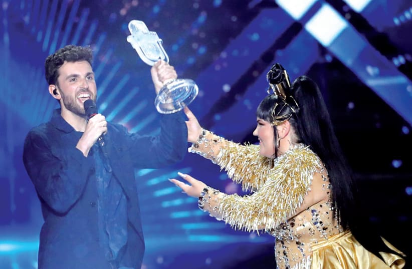 Duncan Laurence of the Netherlands accepts the Eurovision trophy from Israel’s Netta Barzilai. (photo credit: RONEN ZVULUN / REUTERS)