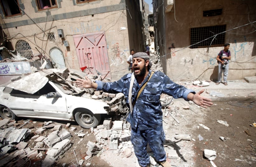 A Houthi security officer reacts at the site of an air strike launched by the Saudi-led coalition in Sanaa, Yemen May 16, 2019 (photo credit: REUTERS/MOHAMED AL-SAYAGHI)