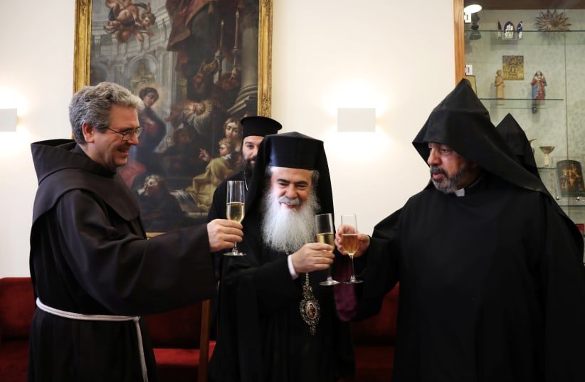 Custodian of the Holy Land Father Francesco Patton, Greek Orthodox Patriarch of Jerusalem Metropolitan Theophilos and Armenian Patriarch of Jerusalem Nourhan Manougian, celebrate after signing agreements giving their approval for a restoration project for the Church of the Holy Sepulchre, in Jerusal (photo credit: AMMAR AWAD / REUTERS)