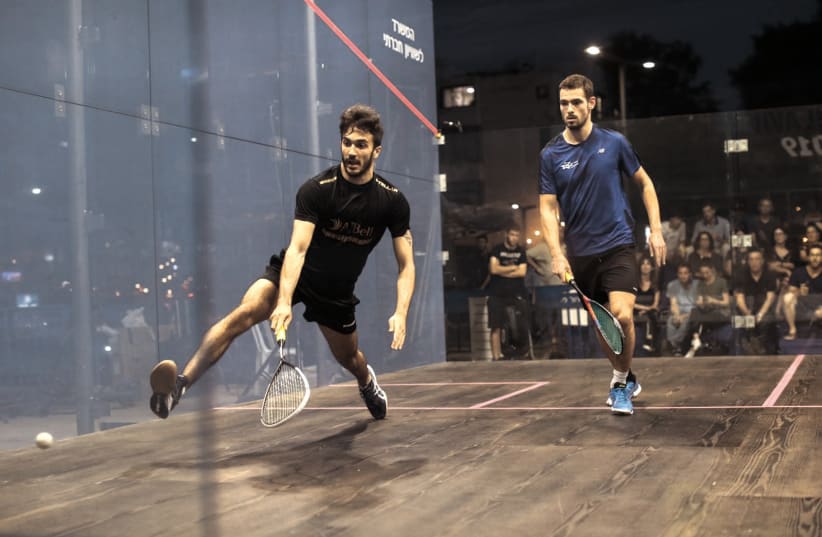 A pair of competitors take part in the professional squash tournament on Wednesday night in the outdoor glass court built in the center of Tel Aviv (photo credit: NIMROD ARONOV / COURTESY)