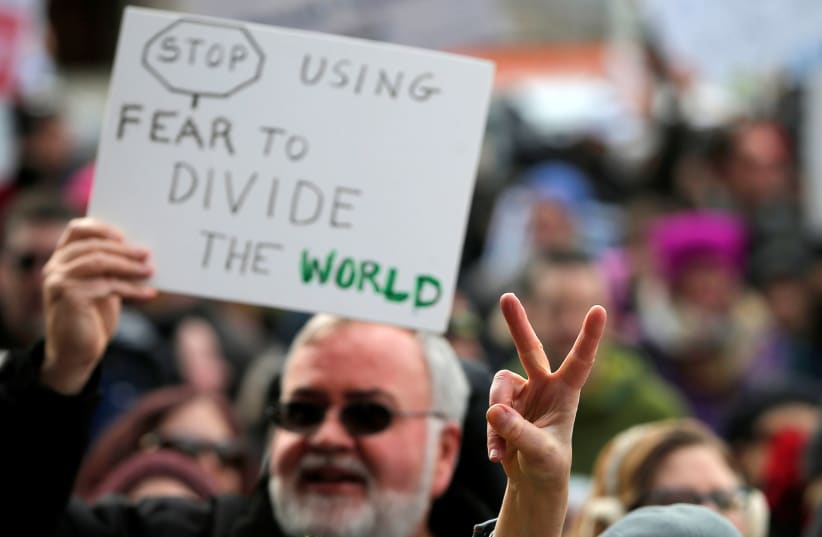 A sign is seen about the crowd at "Boston Protest Against Muslim Ban and Anti-Immigration Orders" protesting U.S. President Donald Trump's executive order travel ban in Boston, Massachusetts, U.S. January 29, 2017 (photo credit: BRIAN SNYDER / REUTERS)