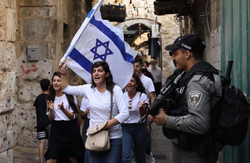 Jewish women march while police patrol in the Old City during Jerusalem Day, 2019 (photo credit: MARC ISRAEL SELLEM/THE JERUSALEM POST)