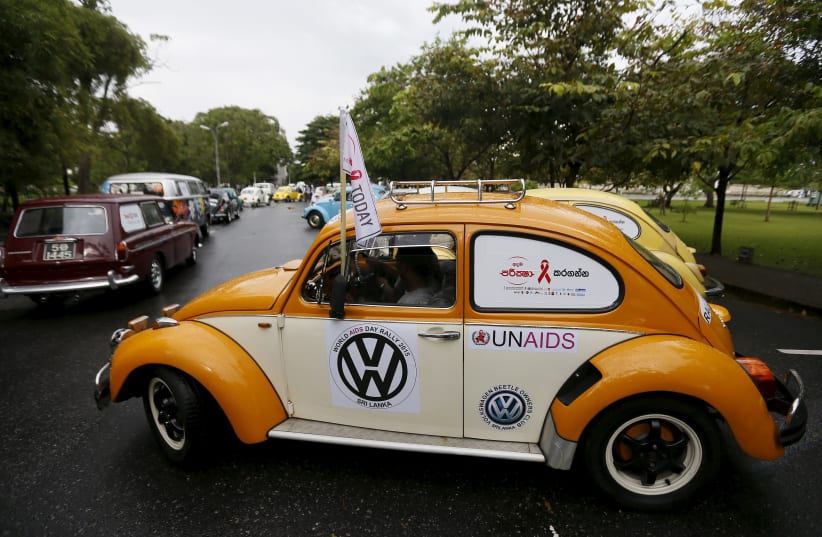 Volkswagen beetle cars drive in a file during a "World AIDS Day 2015" rally  (photo credit: REUTERS/DINUKA LIYANAWATTE)