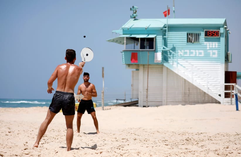 People play paddle ball, known in Hebrew as "matkot", a popular Israeli sport, at a beach in Ashkelon, Israel May 7, 2019. (photo credit: AMIR COHEN/REUTERS)