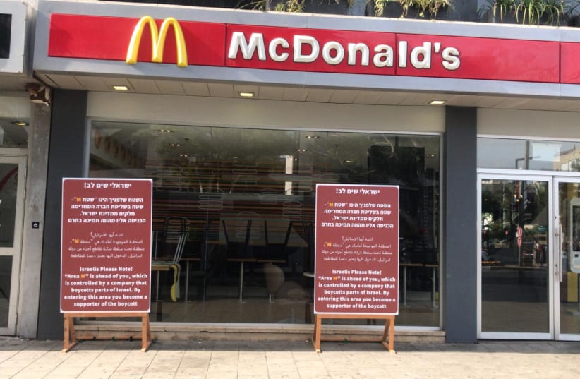 Signs outside a McDonald's in Tel Aviv protest the refusal of the local franchise to open in Judea and Samaria. (photo credit: MAARIV)