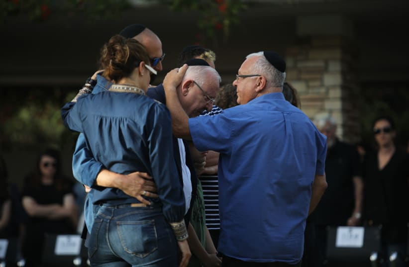President Reuven Rivlin is comforted by family at his wife's funeral on Mt. Herzl, in Jerusalem, June 5, 2019 (photo credit: HADAS PARUSH/FLASH90)
