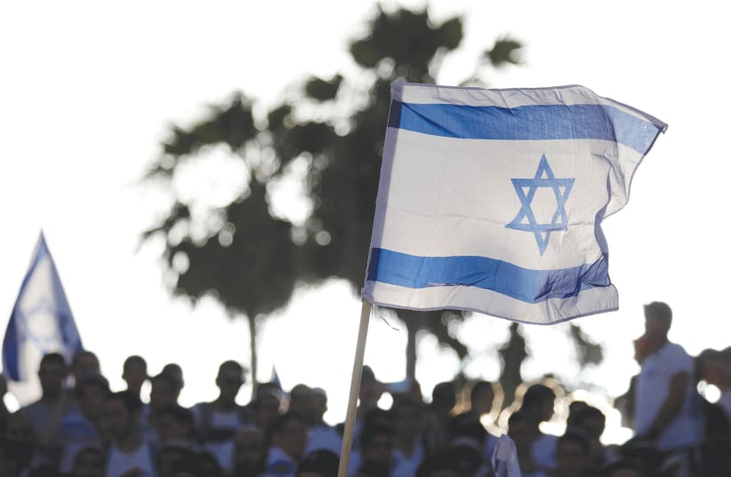 AN ISRAELI flag held aloft on Jerusalem Day.  (photo credit: REUTERS)