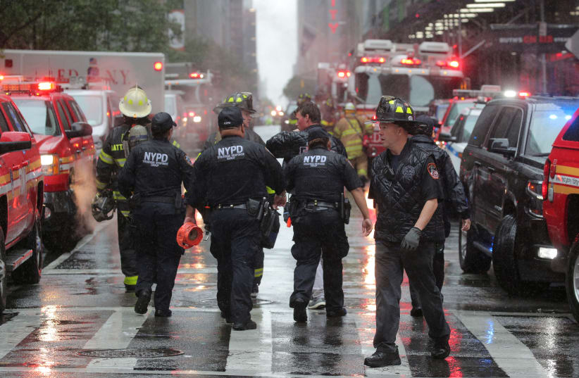 New York City police and firefighters arrive at the scene after a helicopter crashed atop a building in Times Square and caused a fire on the roof in the Manhattan borough of New York, New York, U.S., June 10, 2019. (photo credit: BRENDAN MCDERMID/REUTERS)