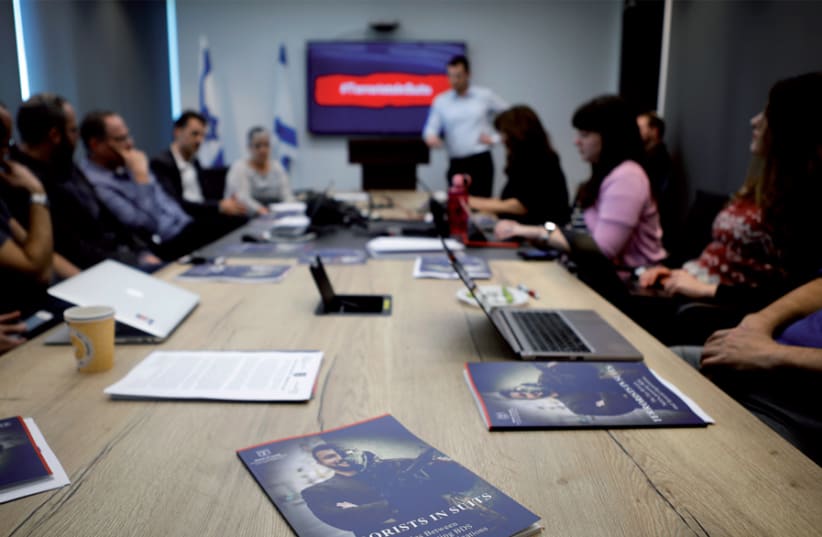 Israel’s Ministry of Strategic Affairs briefs reporters in Bnei Brak on February 3 on its new report revealing ties between terrorist groups and NGOs that support the BDS movement (photo credit: NIR ELIAS / REUTERS)