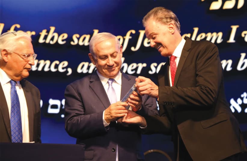DR. MIKE EVANS presents Prime Minister Benjamin Netanyahu with a gift, while US Ambassador to Israel David Friedman looks on. (photo credit: Courtesy)