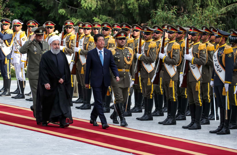 Iranian President Hassan Rouhani walks with Japan's Prime Minister Shinzo Abe, during a welcome ceremony in Tehran, Iran, June 12, 2019. (photo credit: REUTERS)