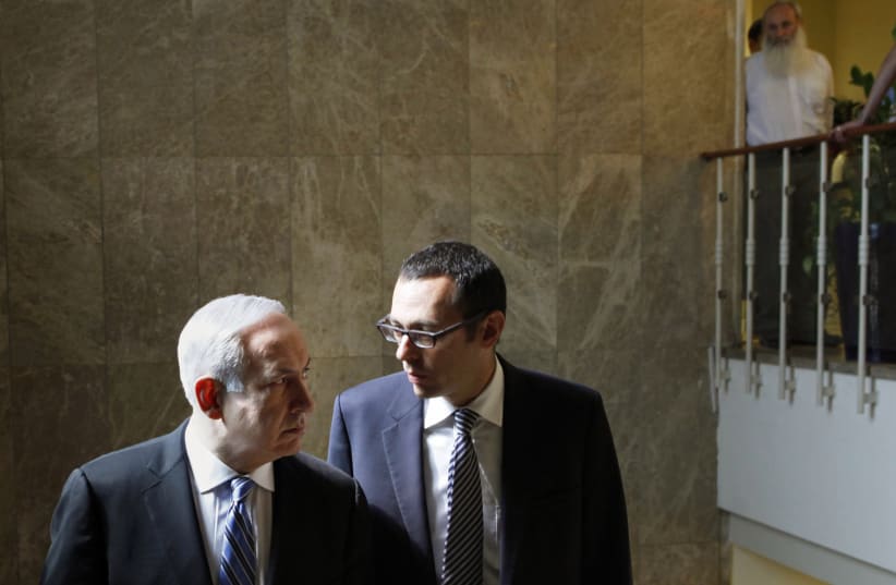 Former cabinet secretary Zvi Hauser and Prime Minister Benjamin Netanyahu. (photo credit: GALI TIBBON/REUTERS)