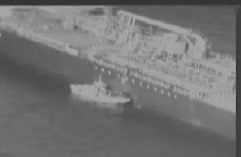 Still image taken from a U.S. military handout video purports to show Iran's Revolutionary Guard (IRGC) removing an unexploded limpet mine from the side of the Kokuka Courageous Tanker (photo credit: REUTERS)