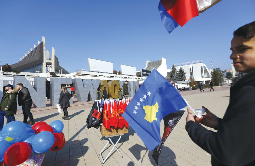 A MAN holds a Kosovo flag (photo credit: REUTERS)