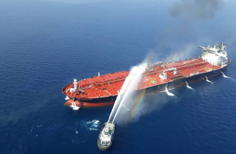 An Iranian navy boat tries to stop the fire of an oil tanker after it was attacked in the Gulf of Oman (photo credit: TASNIM NEWS AGENCY/HANDOUT VIA REUTERS)