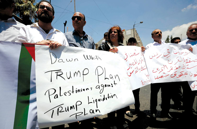 PALESTINIANS IN Ramallah hold signs last week during a protest against the upcoming US-led Mideast economic workshop in Bahrain (photo credit: REUTERS/MOHAMAD TOROKMAN)