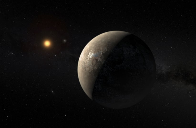 The planet Proxima b orbiting the red dwarf star Proxima Centauri, the closest star to our Solar System, is seen in an undated artist's impression.  (photo credit: REUTERS)