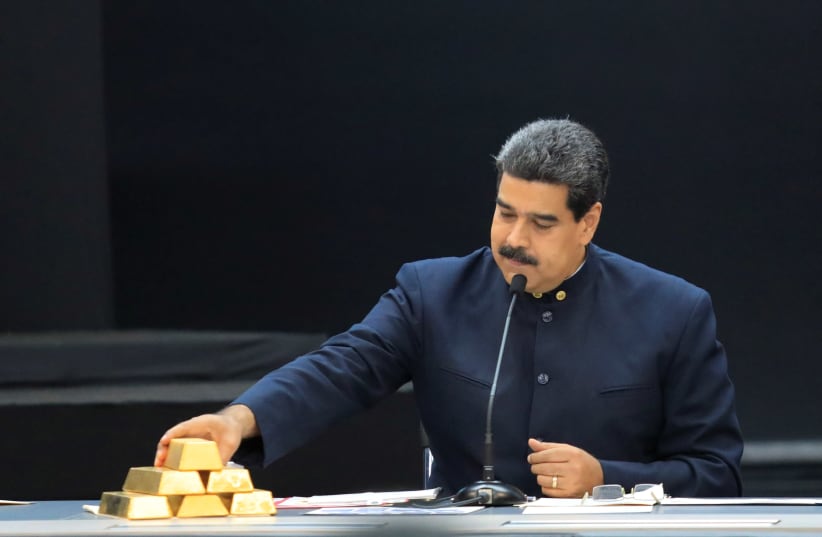 Venezuela's President Maduro touches a gold bar as he speaks during a meeting with the ministers responsible for the economic sector in Caracas (photo credit: MARCO BELLO/REUTERS)